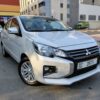 A grey Mitsubishi Attrage 2025 sedan parked in Dubai, featuring a compact fuel-efficient design, 1.2L petrol engine with automatic CVT transmission, spacious interior, and modern safety features, ideal for affordable sedan car rental in Dubai.