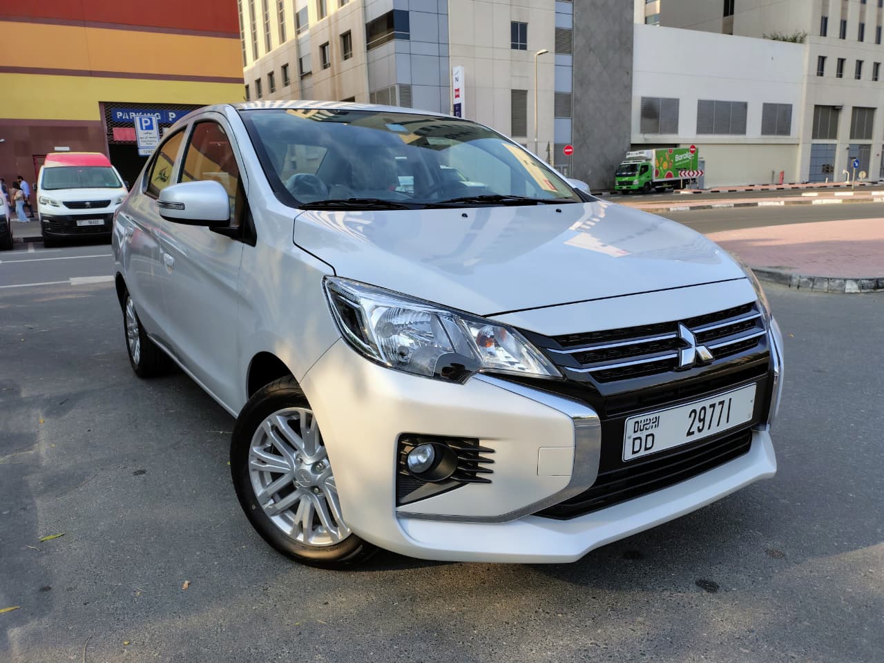 A grey Mitsubishi Attrage 2025 sedan parked in Dubai, featuring a compact fuel-efficient design, 1.2L petrol engine with automatic CVT transmission, spacious interior, and modern safety features, ideal for affordable sedan car rental in Dubai.